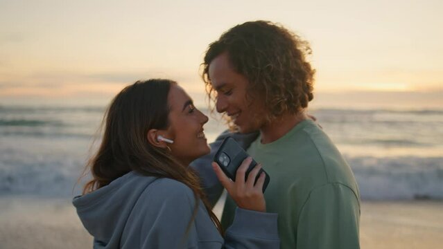 Enamoured woman man dancing on sundown beach. Romantic couple listening music