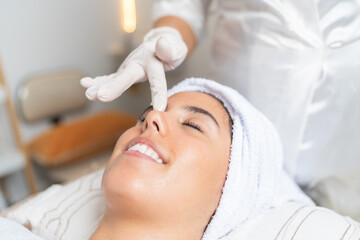 Happy woman in a beauty spa lying with eyes closed
