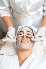 Relaxed woman during a facial peeling in beauty salon