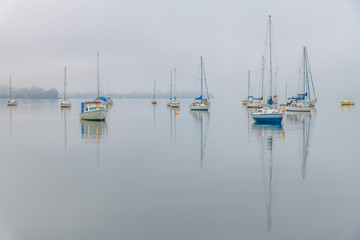 Fog, sunrise and boats on the bay