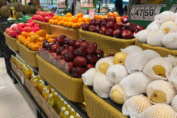 Various type of fresh fruits arrange neatly in grocery store. Pear, apple and orange on rack.