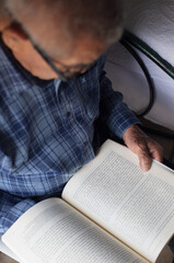 Adulto mayor de tercera edad leyendo libro 