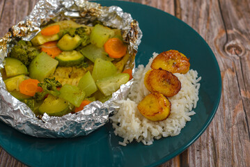 Baked fish with vegetables in aluminum foil. Healthy food.