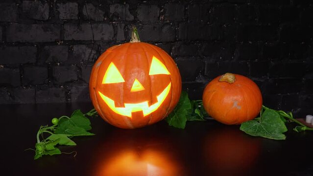 The bigest and the smallest pumpkin are waiting for the Halloween night in a dark room