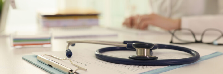 Stethoscope and medical records on doctor table in hospital