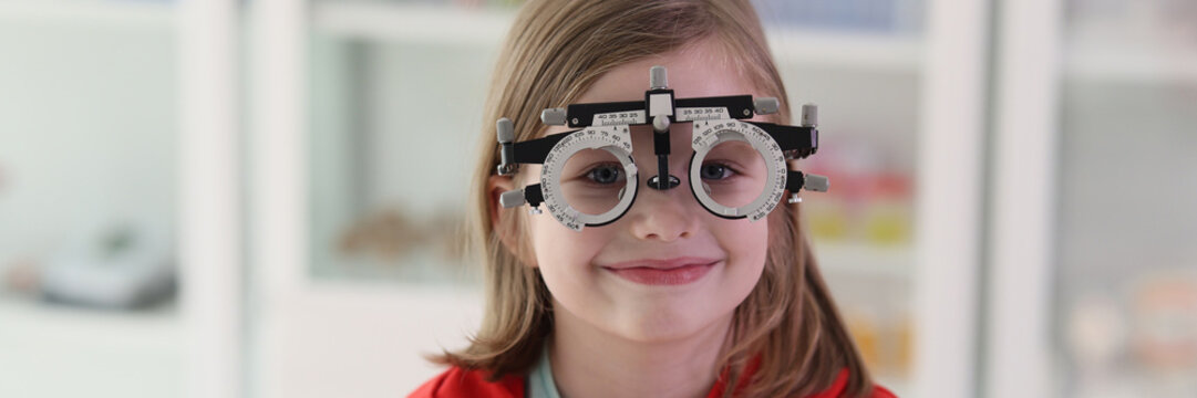 Girl with eye examining tool at ophthalmologist appointment