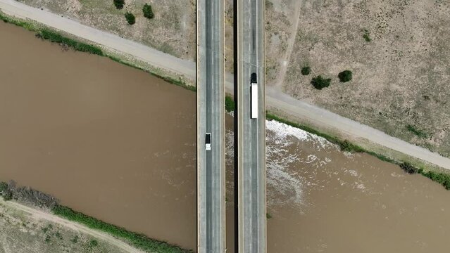 Top down shot of highway bridge over Rio Grande. Aerial shot of traffic crossing large river in USA that border Mexico.
