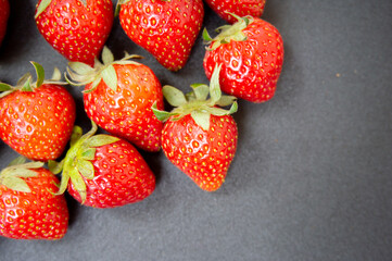 closeup of fresh strawberries on a dark background for use in various media