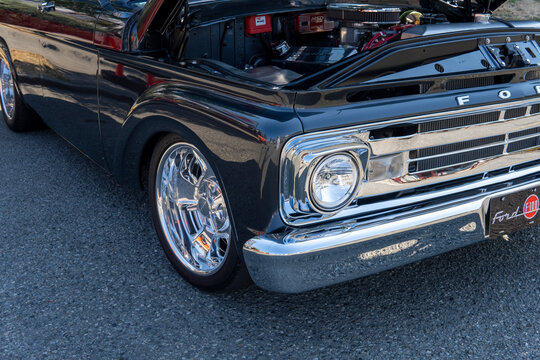 Snohomish, WA, USA - 25 September 2022. Headlight of Black Ford F100 Pickup Truck 1965 with open car hood
