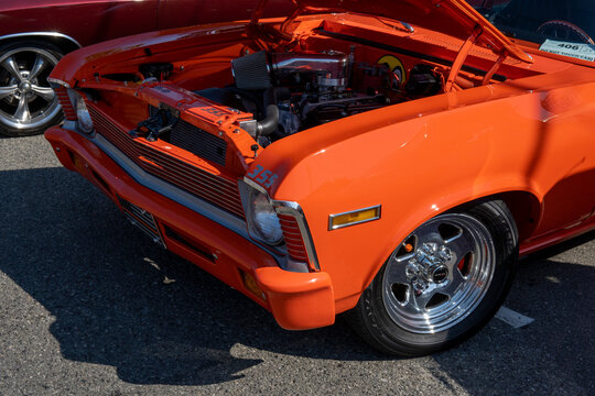 Snohomish, WA, USA - 25 September 2022. Headlights of orange Chevrolet Nova SS with open car hood. 1972 orange Chevy at car exhibition
