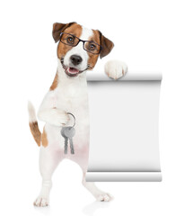 Smart Jack russell terrier puppy wearing eyeglasses holds in his paw the keys to a new apartment and shows empty list. Isolated on white background