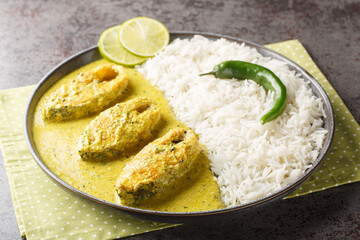 Hilsa fish in Mustard Sauce or shorshe Ilish served with white rice closeup on the plate on the table. Horizontal - obrazy, fototapety, plakaty