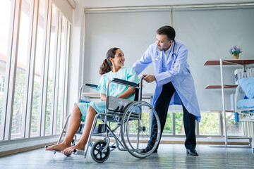 Fototapeta na wymiar Doctor taking care and talking mature female patient sitting on wheelchair in hospital. Healthcare concept, Banner cover design.