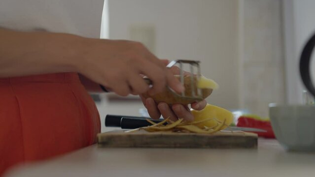 Close up of a woman peeling potatoes on the kitchen counter. Panasonic Lumix S5 with a 75mm lens.