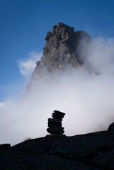 A cairn and clouds in the mountains.