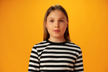 Upset disturbed teen girl on yellow background in studio