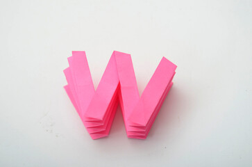 creativity idea, origami alphabet double U, in pink collor. Isolated white background