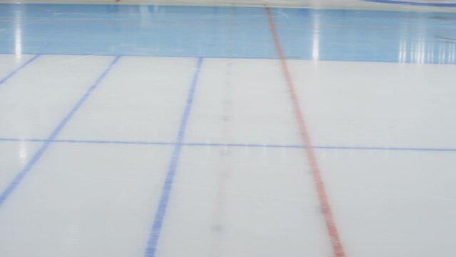 Medium slowmo shot of multiethnic male speedskating group crossing finish line in ice rink