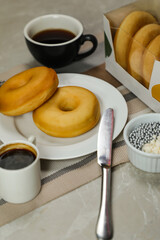 Plain Donuts with dip and cup of coffee isolated on napkin side view of baked food breakfast on table