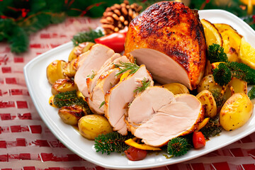 Roasted turkey slices surrounded by potatoes and roasted vegetables on the Christmas table - obrazy, fototapety, plakaty