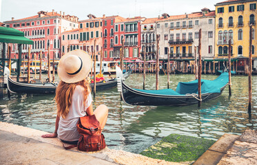 Traditional gondolag on grand canal with woman traveler enjoying tranquil scene- Venice in Itlay © M.studio