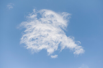 White puffy cloud on blue background. Weather conditions concept