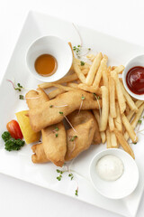 british traditional fish and chips meal in restaurant on white plate - 657470059