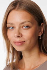 Naklejka premium Beautiful young girl with fresh healthy skin. Woman advertise ear-rings. White background. Earrings, ear caffs closeup. Blond european woman with long hair with big lips, pretty smile. Cosmetology