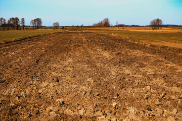 freshly plowed field in early spring. tractor marks. virgin soil