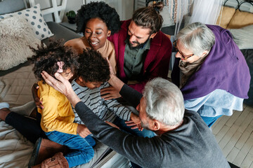 Three generational happy multiethnic diverse family having fun, enjoying time together at home