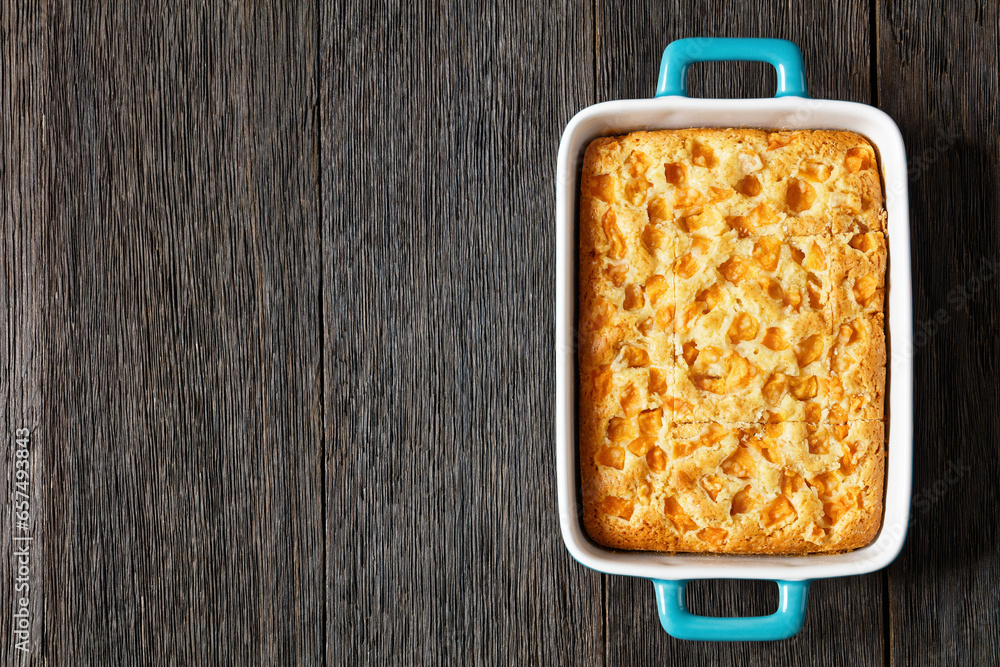 Wall mural peach cake in baking dish on dark wooden table