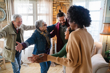 Excited multiethnic family greeting grandparents on Christmas Day. Multi-generational happy family