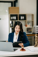 Beautiful asian woman lawyer working and gavel, tablet, laptop in front, Advice justice and law concept.