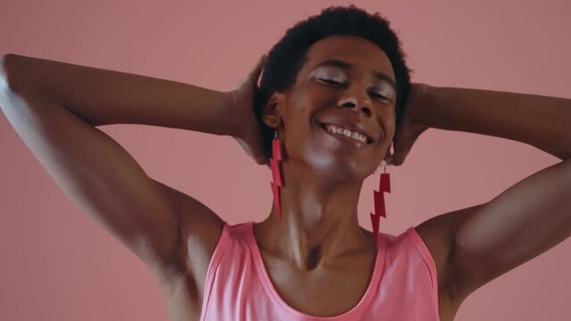 Gender fluid young man wearing fashionable clothes posing in studio on colored backgrounds