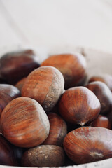 Close up chestnuts in a bowl on a wooden table with space for text.
