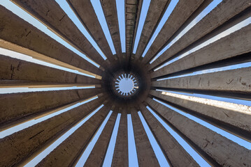 Abstract photo in a bottom view of a concrete monument with several pillars scattered in a circular...