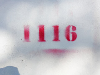 red spray number 1116 on wall