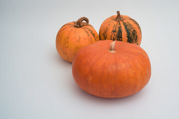 Three big orange Halloween pumpkins on a white background