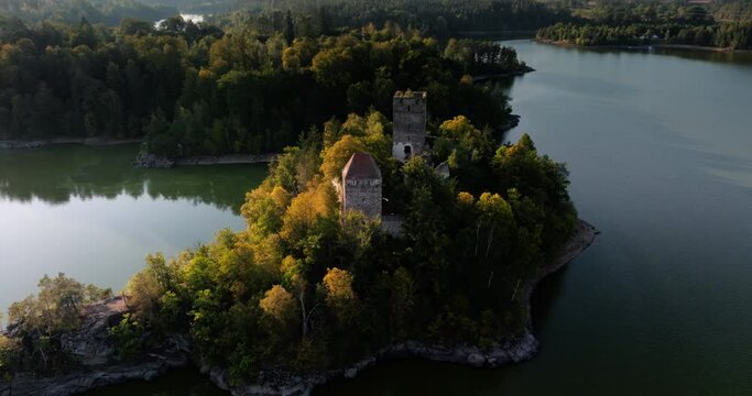 Aerial orbit around Ottenstein castle ruins, cinematic sun flare and long shadows on water