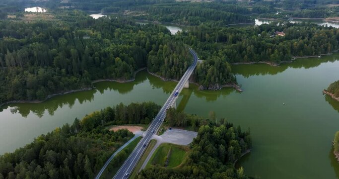 Cars rush across bridge spanning Stausee Ottenstein reservoir in the evening, Austria, drone view