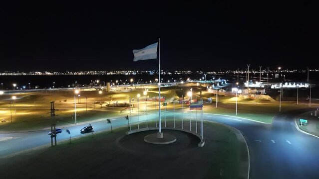 Flag of Argentina in the middle of roundabout in heavy wind at night.