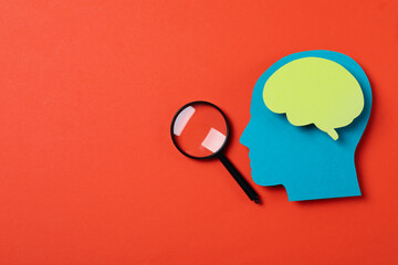 Magnifying glass and decorative head on red background, space for text
