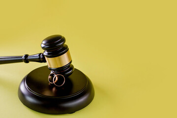 Closeup of wedding rings on wooden mallet at table in courtroom