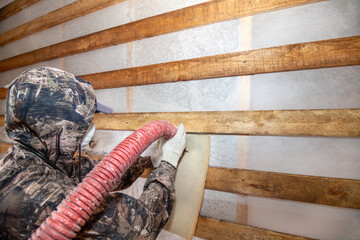 Blowing ecowool into a wall in a frame house