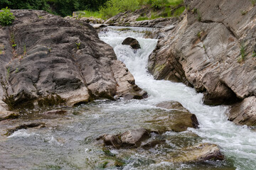 Obraz premium Waterfall on the mountain river at spring overcast evening