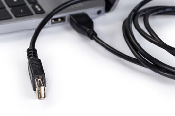 USB extension cable connected to laptop close-up, selective focus