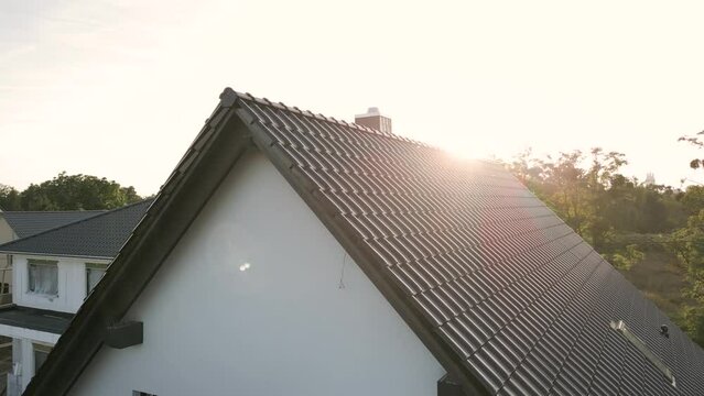 Sunset over the roof of a detached house in a suburban area