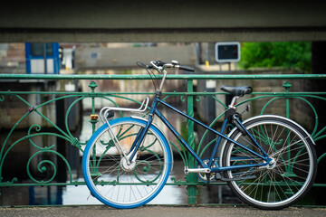 Obraz premium Vieux vélo bleu parqué sur un pont avec un pneu bleu et un noir