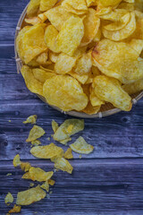Rustic Delight: Golden Potato Chips in a Wooden Bowl - Tempting and Crunchy Snack on a Textured Background. Potato chips in a wooden bowl with isolated background.