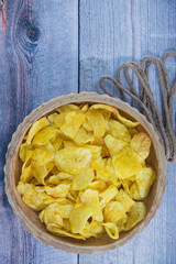 Rustic Delight: Golden Potato Chips in a Wooden Bowl - Tempting and Crunchy Snack on a Textured Background. Potato chips in a wooden bowl with isolated background.